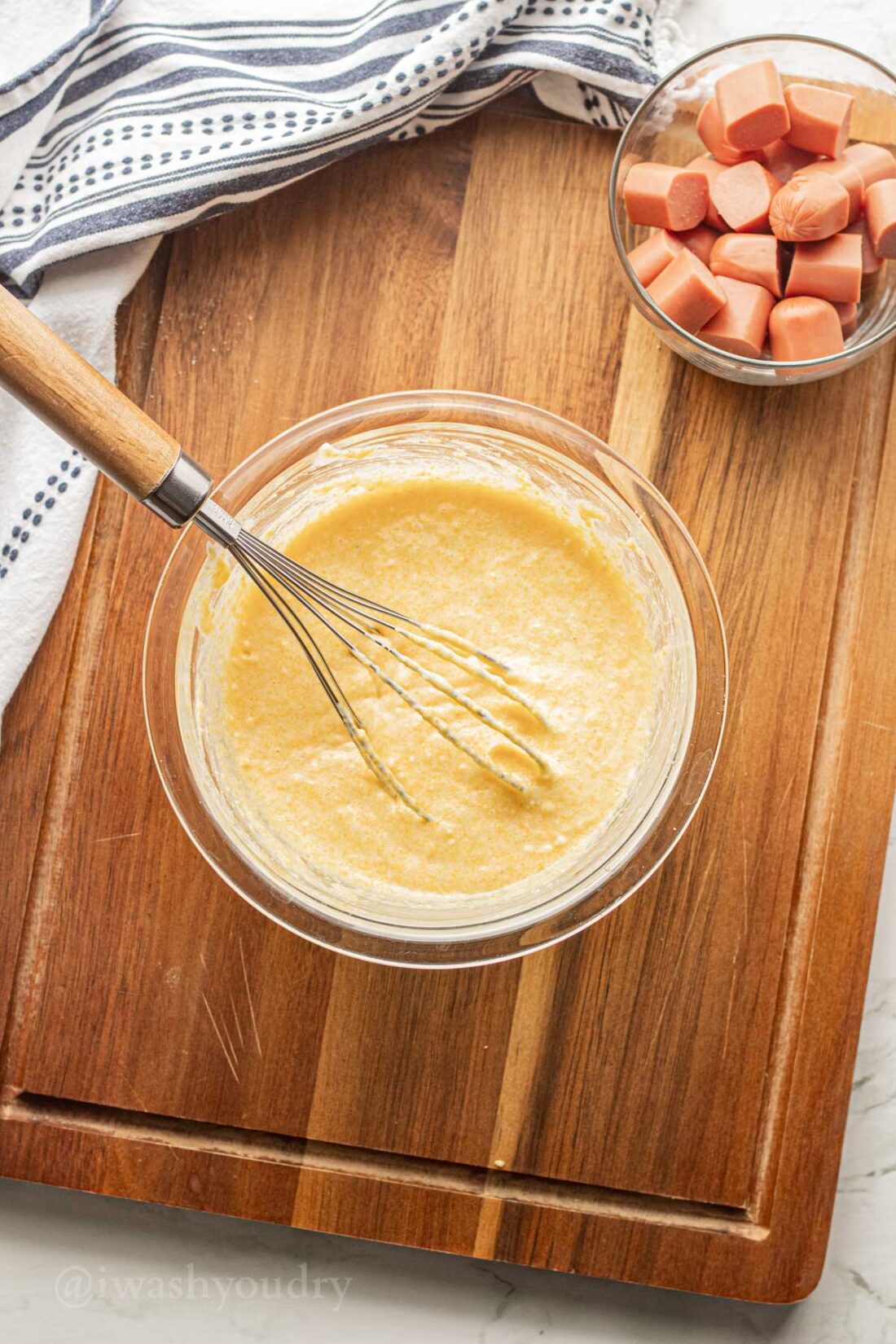 whisking corn muffin mix in glass bowl.