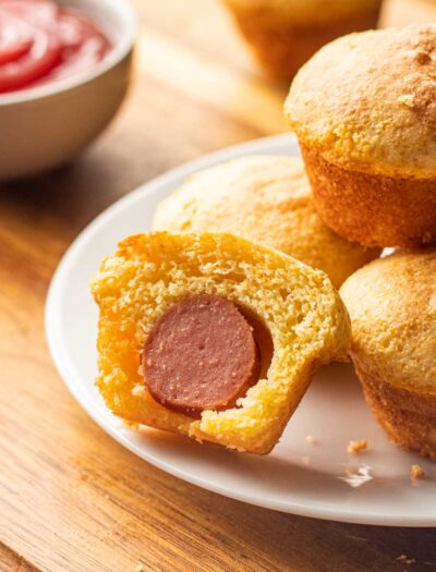 white plate with mini corn dog nuggets and a side of ketchup.