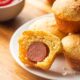 white plate with mini corn dog nuggets and a side of ketchup.