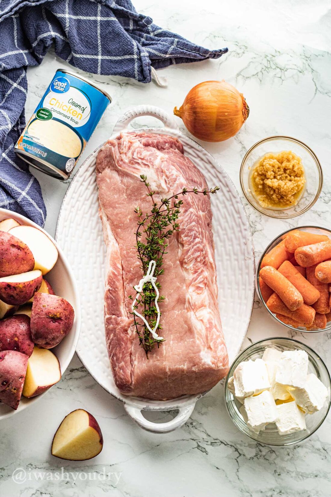 Ingredients for creamy garlic pot roast on white surface.