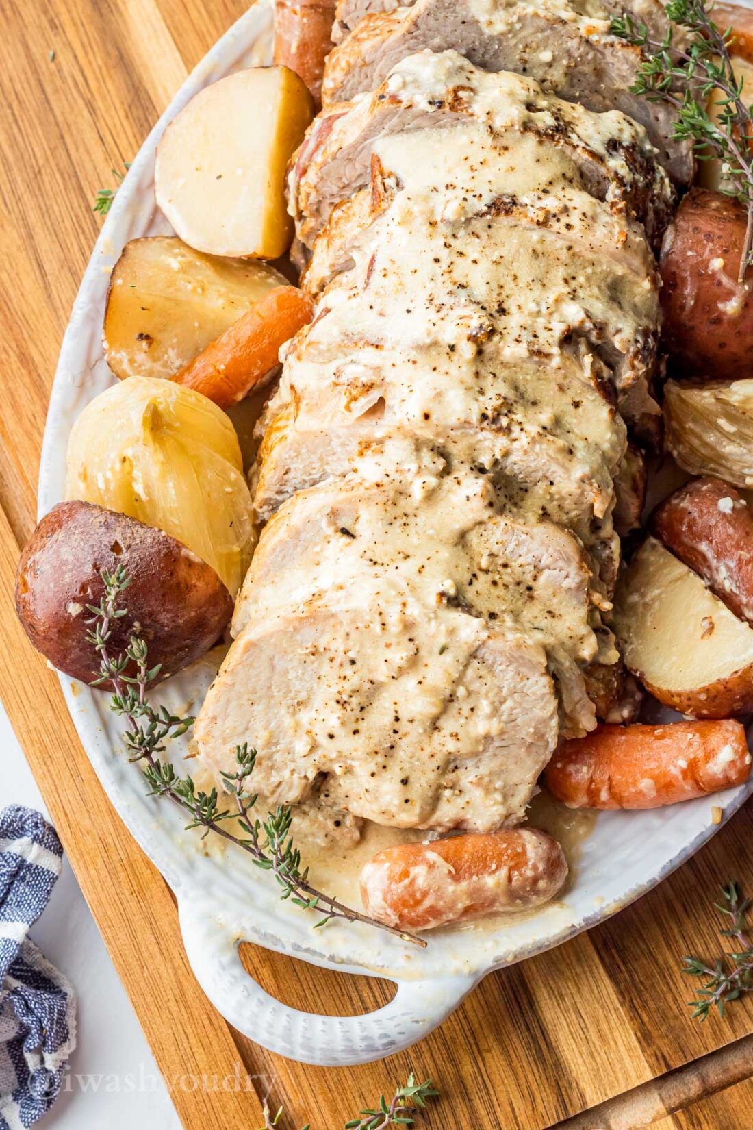 sliced pork roast with creamy garlic sauce and potatoes.