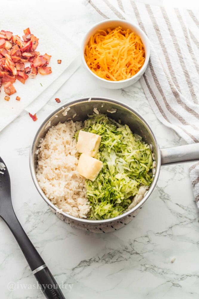 pot of rice with shredded zucchini and butter in it.