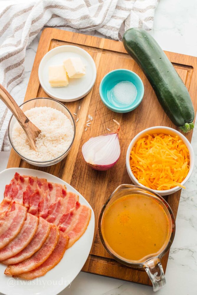 Ingredients needed for rice with zucchini on wooden surface.