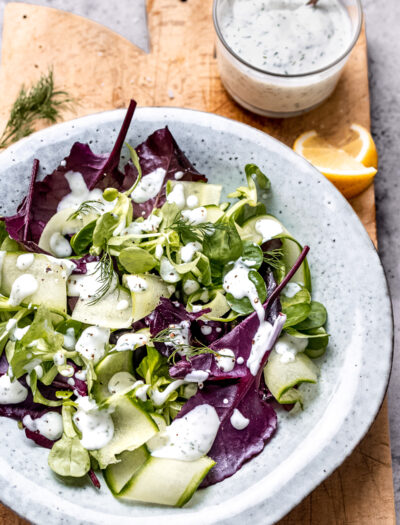 bowl of salad with dressing on top.