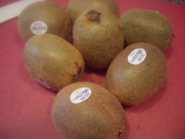 A group of kiwis on a cutting board. 