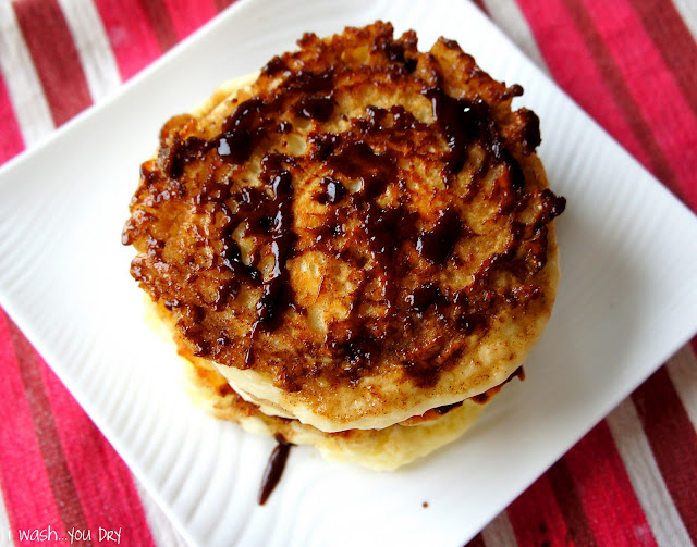 A look down on a stack of cinnamon roll pancakes displayed on a plate.