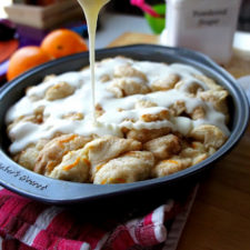 Icing drizzled over a baking pan of Orange Cinnamon Pull Apart in a baking pan