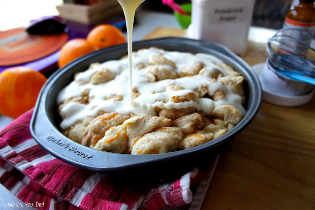 Icing drizzled over a baking pan of Orange Cinnamon Pull Apart in a baking pan