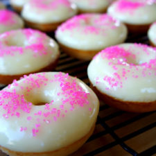 Frosted donuts on a rack with pink sprinkles