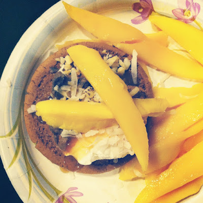 A plate with a cookie and mango slices