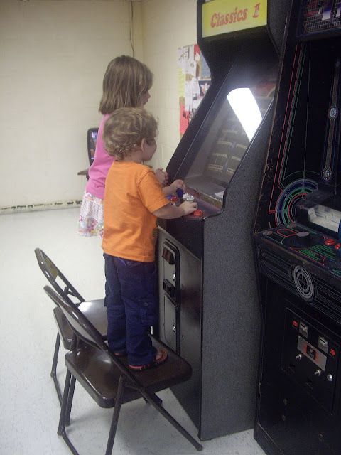 A boy and girl playing arcade games. 