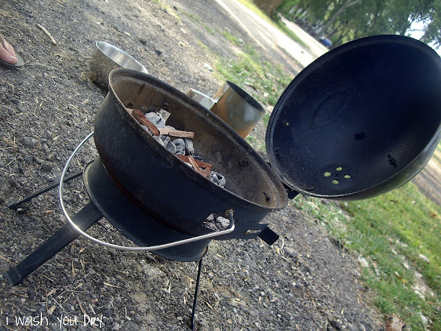 A barbecue with coals and mesquite sticks. 