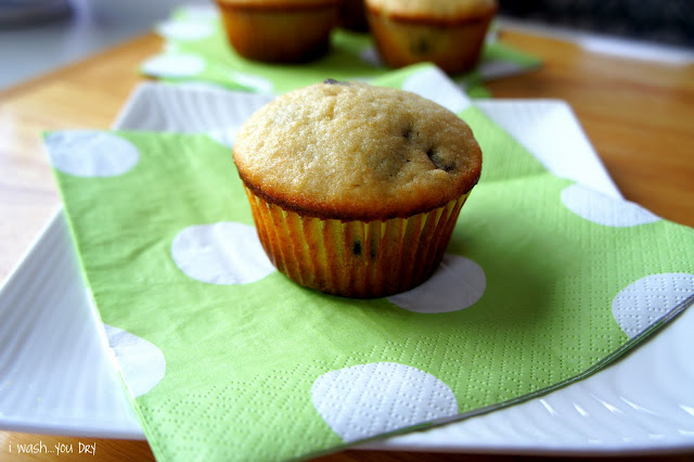 A close up of a baked muffin on a green polka dot napkin.