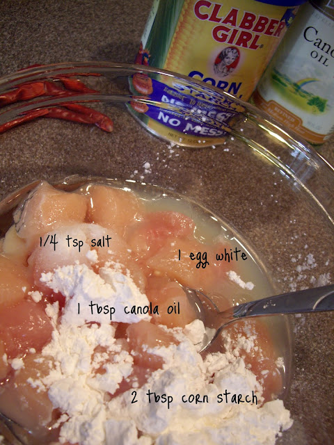 Raw chicken, salt canola oil and egg white in a bowl. 