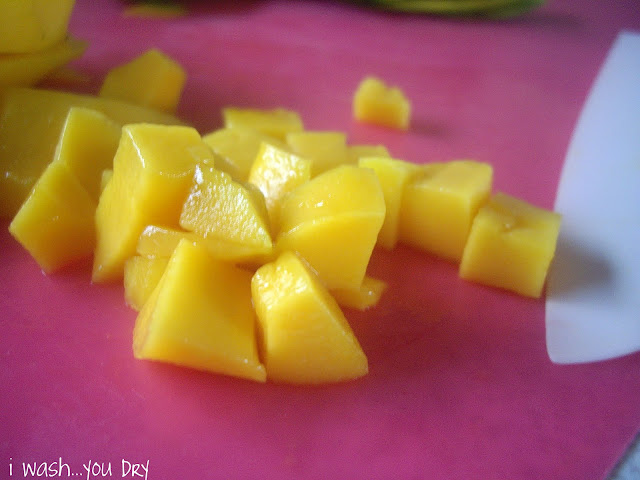 Cubbed mango pieces on a cutting board. 