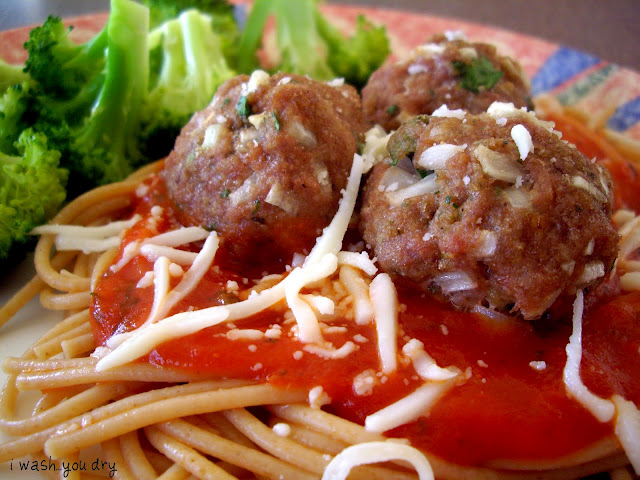 Meatballs on top of spaghetti noodles and a red sauce with side of broccoli.