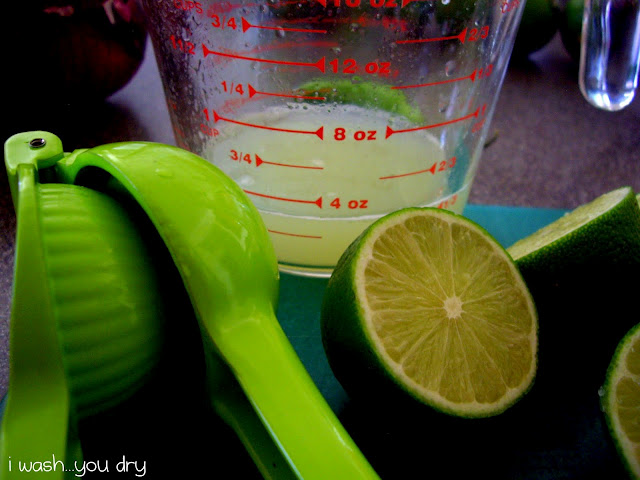 Half a lime in front of a clear measuring cup with lime juice in it. 