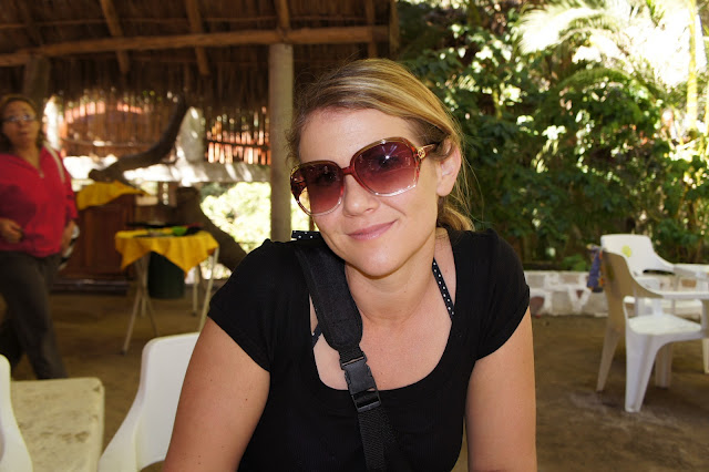 A woman in sunglasses sitting in a restaurant.