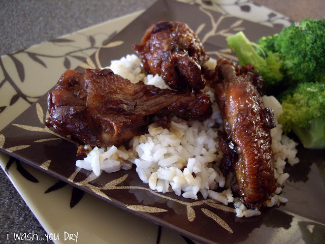 Chicken wings displayed on a plate with rice and broccoli. 