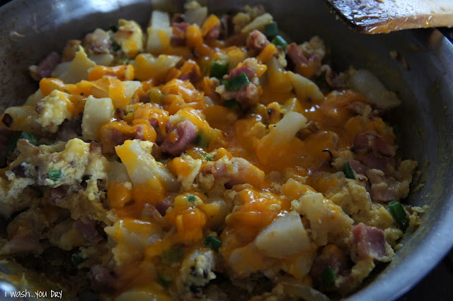 A close up of melted cheese on top of cooked food in a pan.