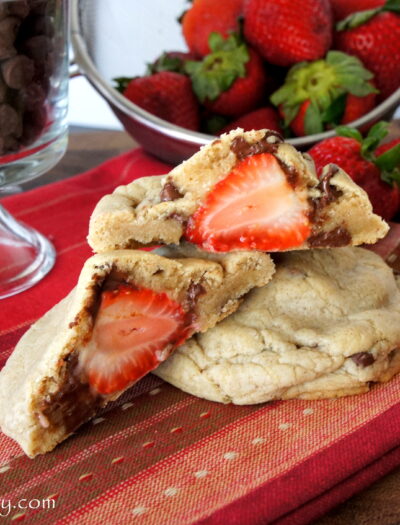 A close up look of a Strawberry stuffed Chocolate Chip Cinnamon Cookie split in half to showcase the stuffed strawberry