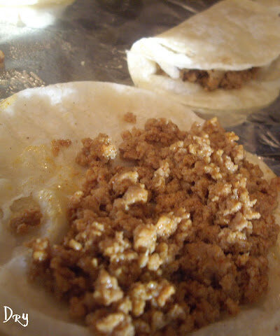 A tortilla with ground turkey meat on it.