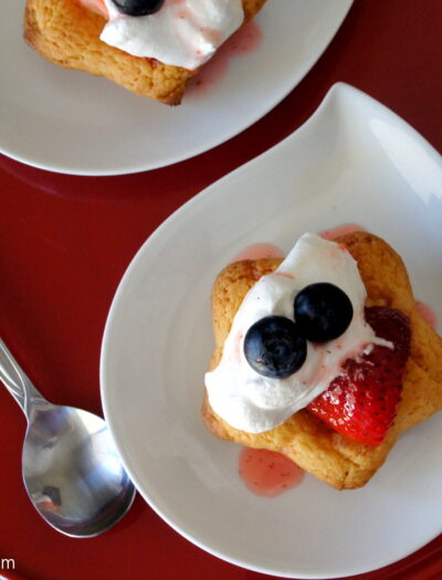 Strawberry Shortcake Cookies topped with whipped cream displayed on a plate.