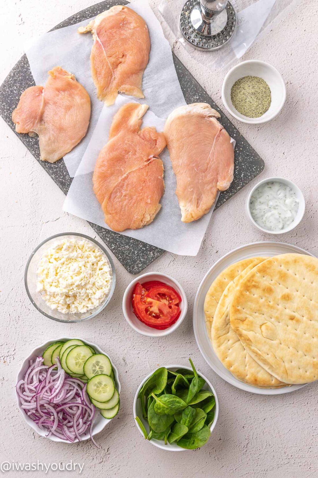 ingredients for chicken souvlaki pitas on white surface.