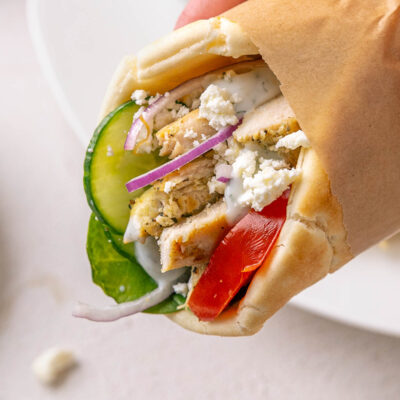 holding chicken pita sandwich with hand.