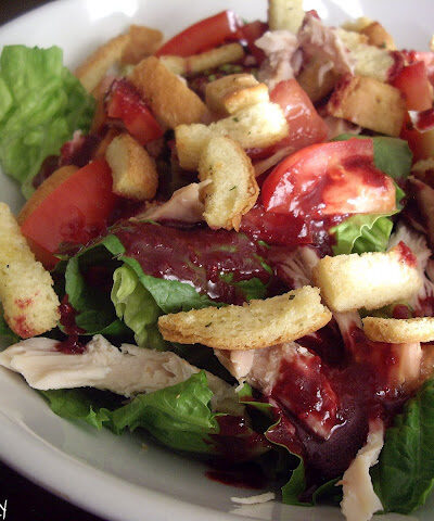 Salad topped with tomatoes and croutons in a bowl.