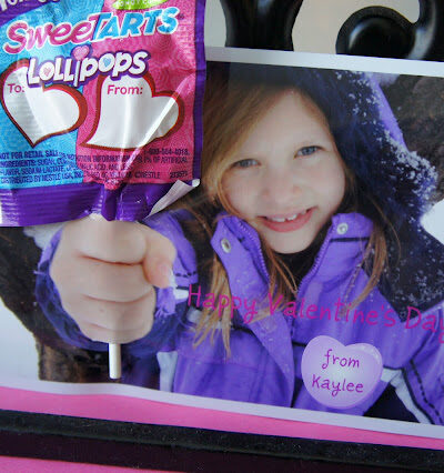 A close up of a Valentine's Day card; picture of little girl holding hand out with a lollipop attached to the picture.