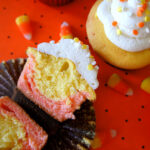 A candy corn styled cupcake sliced in half, displayed next to other candy corn cupcakes