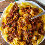 A plate of pasta sauce and noodles on a table