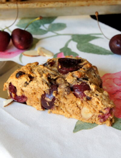 A cherry scone being placed on a napkin