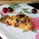 A cherry scone being placed on a napkin