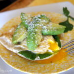 A plate with an Open Faced Egg and Avocado Sandwich on it