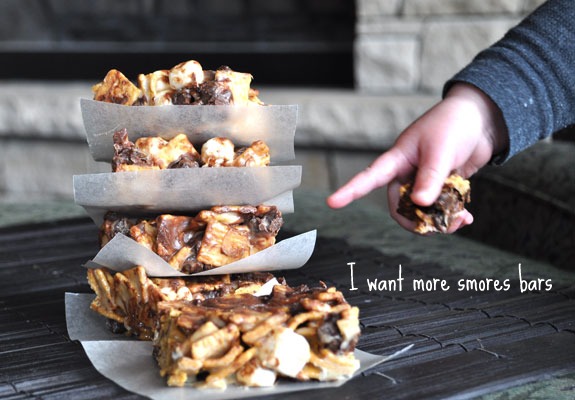 S\'mores bars stacked on top of each other with a little hand pointing to them