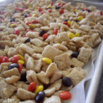 A baking pan of cereal and Reeses pieces.