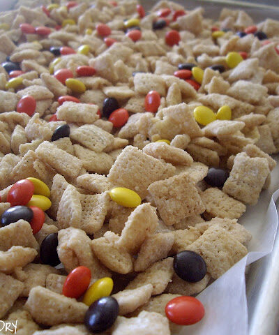 A baking pan of cereal and Reeses pieces.