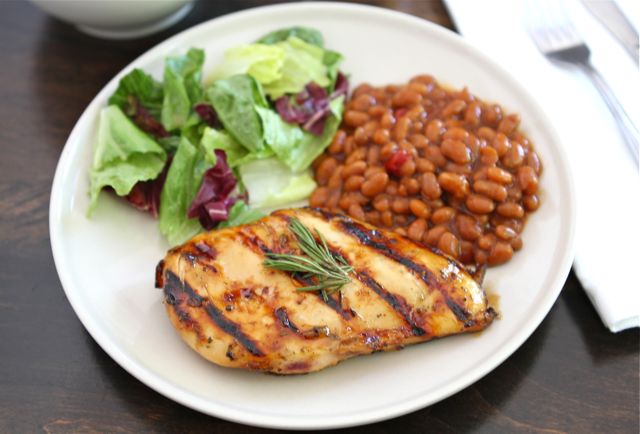 Lemon, Honey & Rosemary Grilled Chicken on a plate, with a side of baked beans and salad