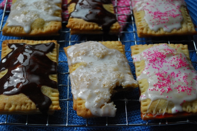 Homemade pop tarts with frosting on them resting on a cooling rack. 