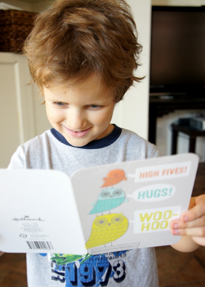 A little boy smiling holding a card