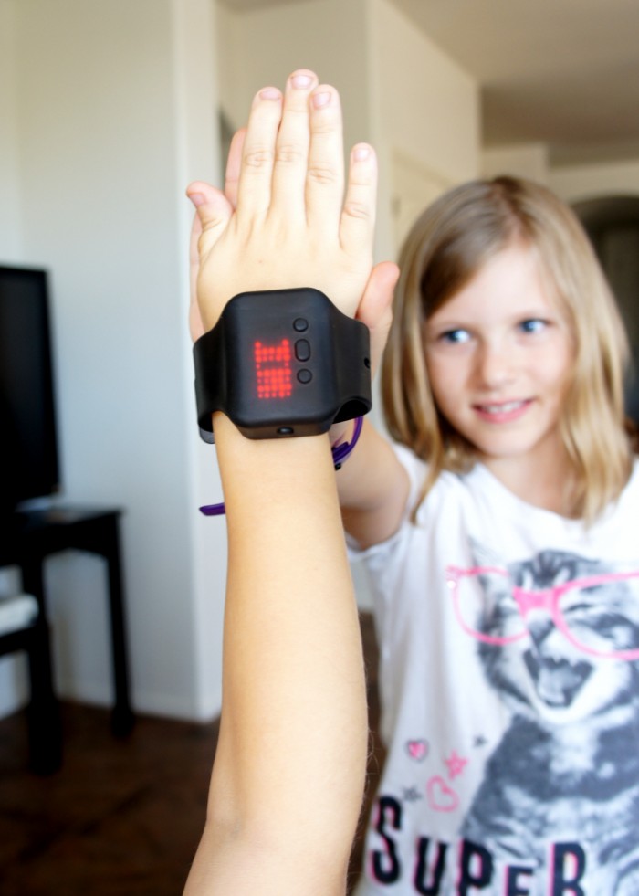 A girl giving a high five to a hand wearing a Text Band