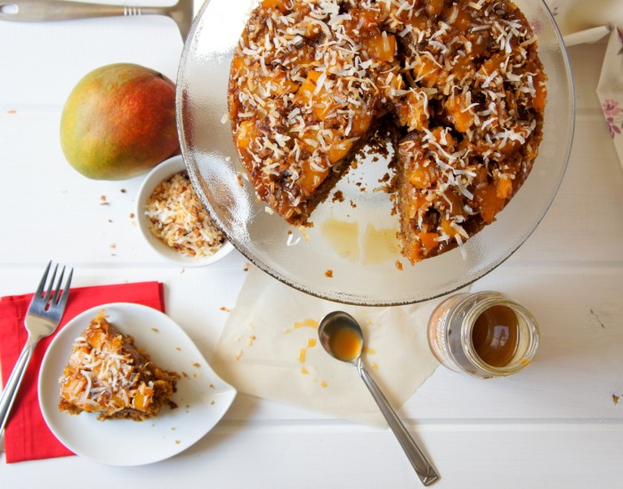 A cake on a cake platter with a slice removed 