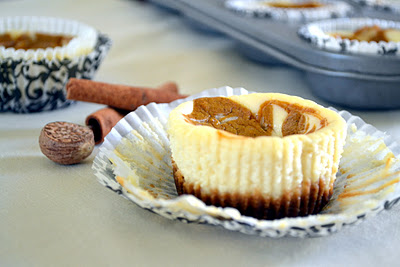 A close up of a pumpkin cheesecake with the muffin wrapper pulled down