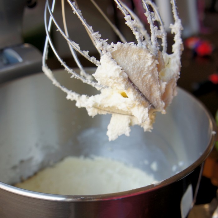 A close up of a beater over a mixing bowl