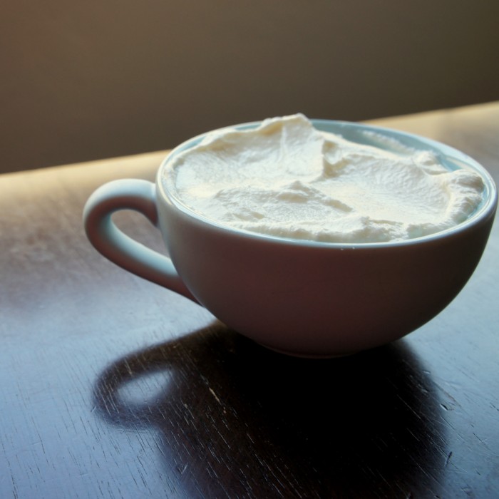 A close up of a measuring cup with yogurt in it