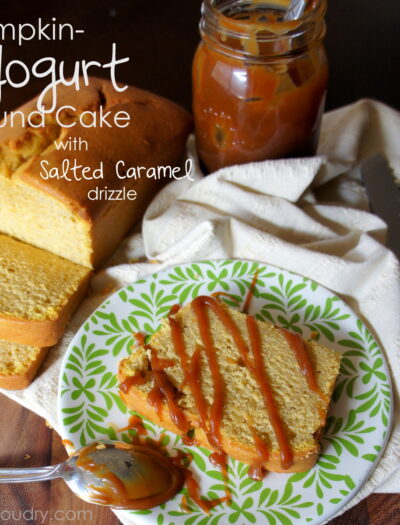 A display with a sliced pound cake and plate with a slice of pound cake on a plate with drizzled salted caramel on it