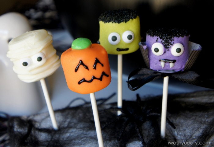 A close up of Halloween themed Marshmallow pops - a mummy, a pumpkin, Frankenstein and a vampire