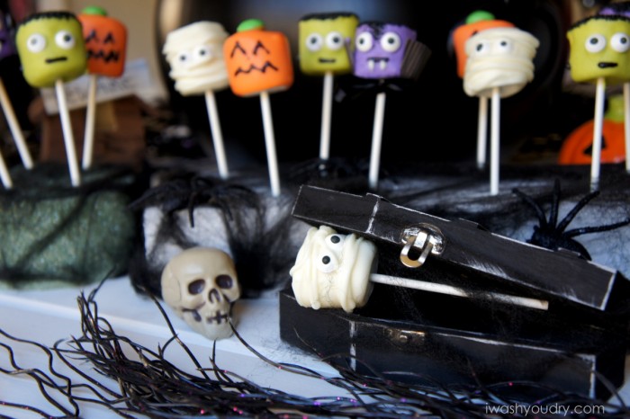 A display of Halloween themed marshmallow pops, surrounded by other Halloween decor